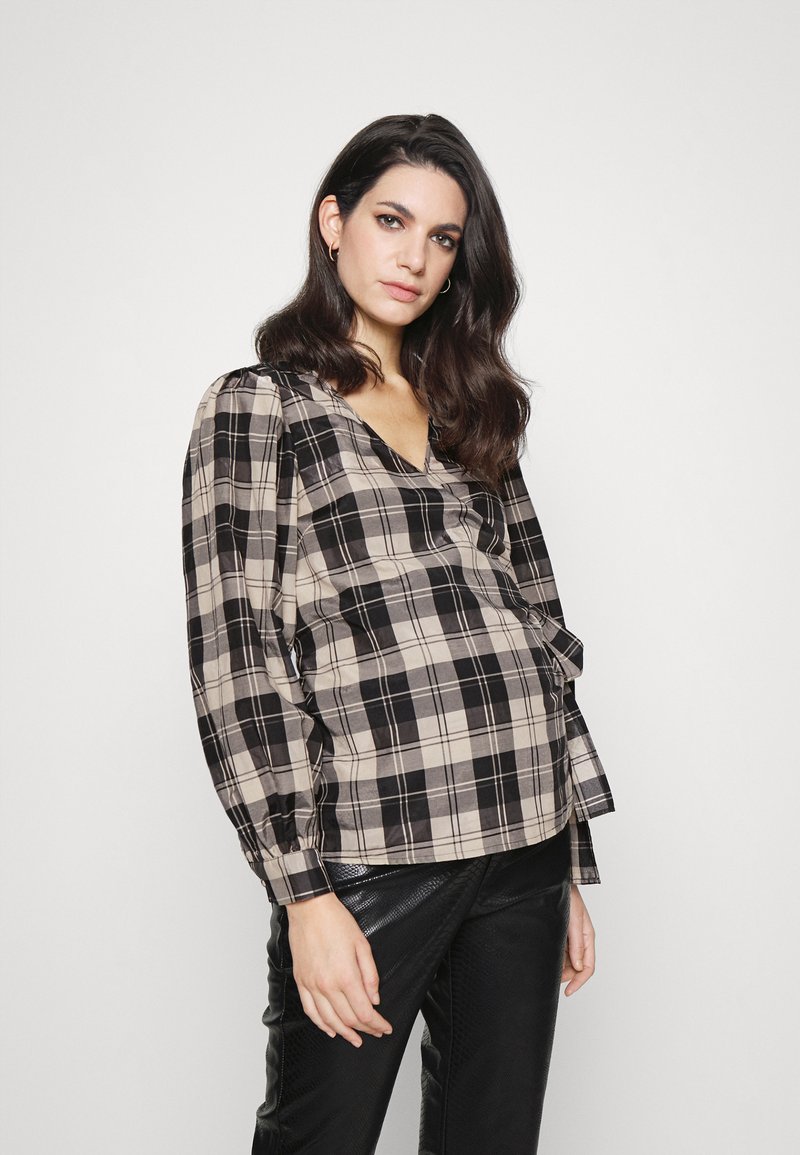 Blusa xadrez em bege e preto, com decote em V, mangas longas bufantes e um corte descontraído. Tecido texturizado com padrão de xadrez visível.
