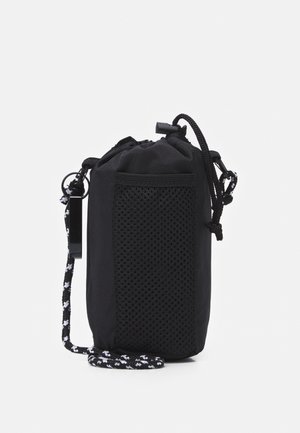 Petit sac noir à cordon avec poche avant en filet et cordon noir et blanc à motif attaché.