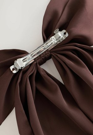 Brun satängroset med veck, fäst med en metallklämma, med en intrikat design. Texturen är slät med en glänsande yta.