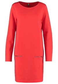 Rode jurk met lange mouwen en een ronde halslijn, met twee ritszakken aan de voorkant. Gemaakt van zachte stof, heeft het een rechte snit.