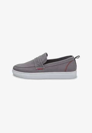 Des chaussures grises à enfiler en toile avec une semelle en caoutchouc blanche. Présentent des détails de couture et un petit accent rouge au talon.