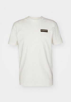 Cremefarbene Baumwoll-T-Shirt mit kurzen Ärmeln, rundem Halsausschnitt und einem kleinen rechteckigen schwarzen und goldenen Logo auf der linken Brustfläche.