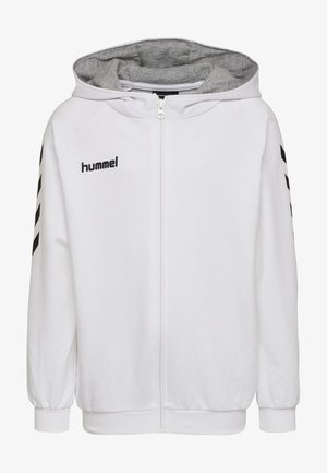 Felpa bianca con zip e interno grigio. Presenta strisce orizzontali nere sulle maniche, polsini a costine e chiusura con zip frontale.