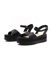 Sandales à plateforme en cuir noir avec un design à bout ouvert, une bride de cheville et des détails tressés texturés sur la semelle intermédiaire. Fini lisse.