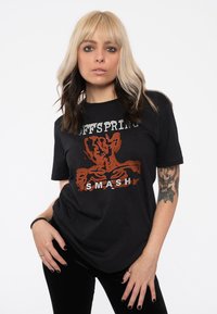 Black cotton t-shirt featuring a distressed graphic design with red and white text reading "The Offspring SMASH" in a relaxed fit.