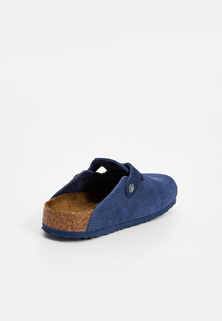 Navyblaue Slip-On Clogs mit strukturiertem Stoffobermaterial, Korkfußbett und Gummisohle. Verfügt über eine dekorative Knopfakzent.