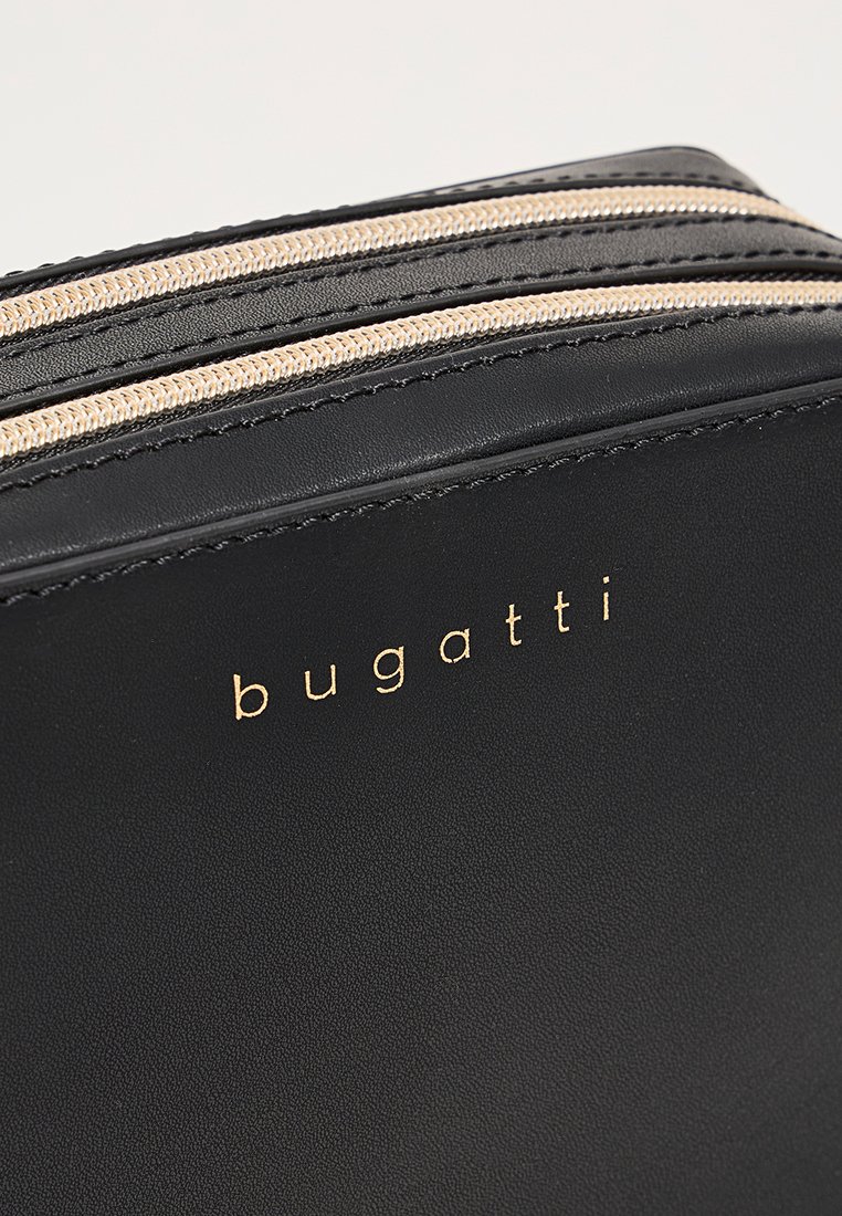 Bolso de piel negra que presenta dos cremalleras en tono dorado y el logo "bugatti" en relieve. Textura suave con un diseño minimalista.