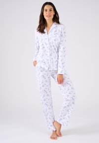 Ensemble de pyjama blanc avec un motif floral bleu clair. Manches longues pour le haut et pantalon droit ; tissu doux avec une texture lisse.