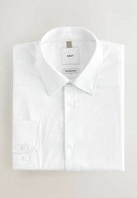 Fehér, hosszú ujjú, gombos ing, szépen összehajtva, hegyes gallérral és dupla gombos mandzsettával, "Next" és "Cotton Rich" felirattal ellátva.