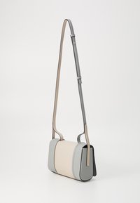 Borsa a tracolla in pelle grigia chiara e beige. Forma rettangolare, superficie liscia, con una tracolla sottile e regolabile e un design minimalista.