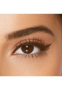 Close-up van een bruine oog met gedefinieerde wimpers en een vleugellijntje. De huid rondom het oog is glad met een natuurlijke toon.