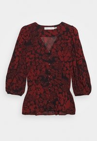 Blusa rossa a fiori con accenti neri, dotata di scollo a V, chiusura con bottoni e maniche a sbuffo. Realizzata in tessuto leggero e testurizzato.