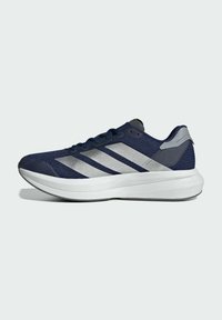Námořnicky modrá sportovní bota s texturovaným textilním svrškem, která má tři stříbrné pruhy, polstrovanou bílou podrážku a šedé detaily na patě.