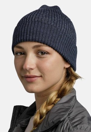 Dark navy knit beanie with ribbed texture, rounded top, and a snug fit. Worn by a person with light brown hair and a gray jacket.