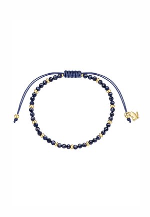 Verstelbare donkerblauwe koordarmband met afwisselend kleine facetgeslepen donkerblauwe en gouden kralen, en een kleine gouden duifbedel aan één uiteinde.