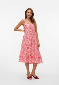Red floral print dress with a fitted bodice, one ruffled strap, and button detailing down the front, made from a lightweight fabric.