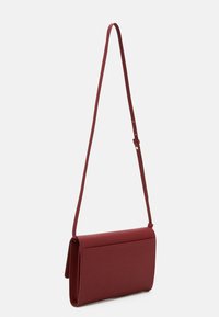 Burgundská crossbody taška z texturovaného materiálu, obdélníkového tvaru s překlápěcí klopou, nastavitelným popruhem a minimálním kováním.