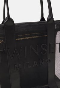 Sac cabas en mesh noir avec poignées en cuir, poche avant zippée et logo embossé "Twinset Milano".
