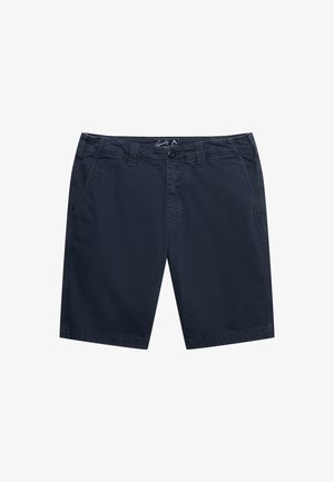 Navy blå knælange shorts med forlommer, bæltestropper, knap og lynlås, lagt fladt på hvid baggrund.