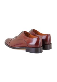 Bruine leren geklede schoenen met een glanzende afwerking, voorzien van een ronde neus, subtiele stiksels en een lage, stevige zwarte hak.