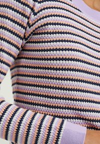 Stickad tröja med ett texturerat mönster i växelvis randiga färger av lavendel, persika och marinblå. Har rund halsringning och åtsittande muddar.