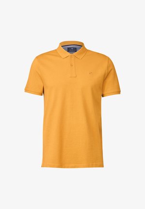 Polo jaune moutarde à manches courtes avec une patte à deux boutons et un petit logo brodé sur la poitrine gauche.