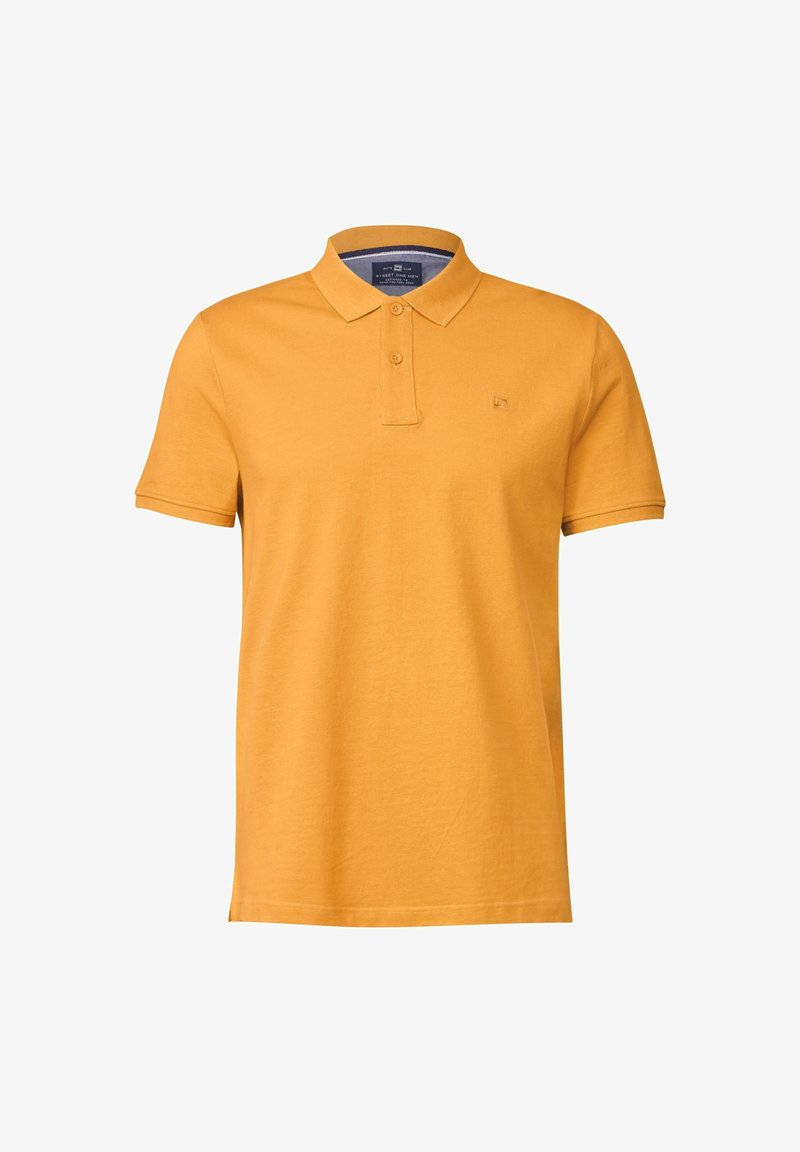 Polo jaune moutarde à manches courtes avec une patte à deux boutons et un petit logo brodé sur la poitrine gauche.