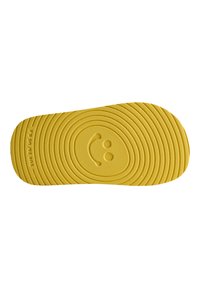 Gul gummisåle med en teksturert, bølgete mønster, med et sentralt smilende ansikt-design og størrelsesmerking: EUR 25/US 8.5.