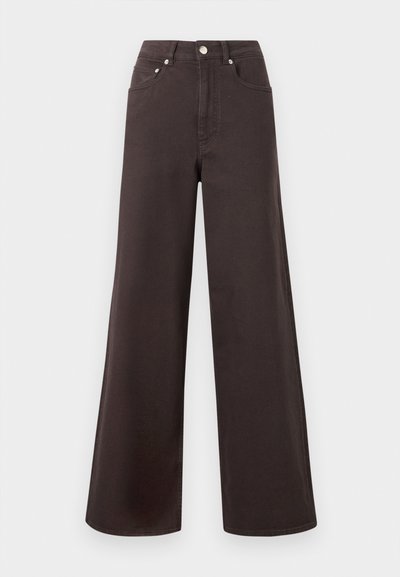 Υψηλομέσατο, φαρδύ παντελόνι τζιν σκούρου καφέ χρώματος με κουμπί εμπρός και τσέπες, παρουσιάζεται σε απλό ανοιχτό φόντο.