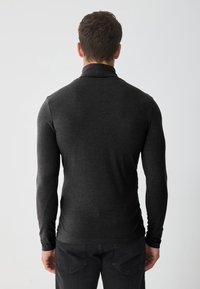 Bluză neagr�ă cu mâneci lungi, realizată dintr-un material moale, cu un guler înalt și un design ajustat. Partea din spate are o ușoară textură și cusături pentru un plus de stil.