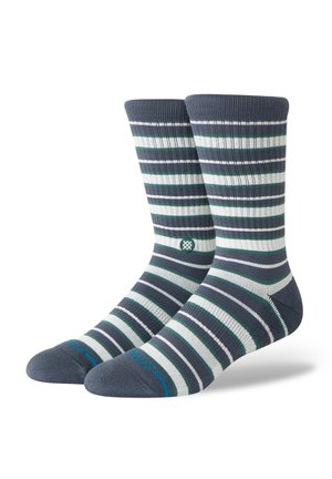 Paire de chaussettes mi-mollet à rayures horizontales en gris foncé, blanc et vert, avec un petit logo circulaire et un texte bleu sur les orteils.