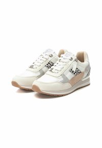 Zapatillas blancas que combinan varios materiales: cuero, malla y ante. Acentos en gris, beige y negro con una suela texturizada. Detalles reflectantes.