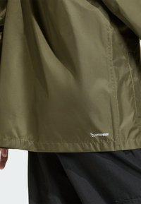 Olívovo zelená vodotesná bunda, vyrobená z látky s jednoduchým dizajnom a viditeľným logom "CLIMAPROOF" na leme a hladkou textúrou.