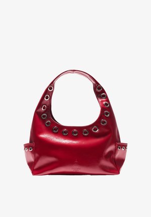 Červená kabelka z lesklej koženky s oblým rúčikom, veľkými kruhovými výrezmi a kovovými očkami. Hladká textúra a pevný tvar.