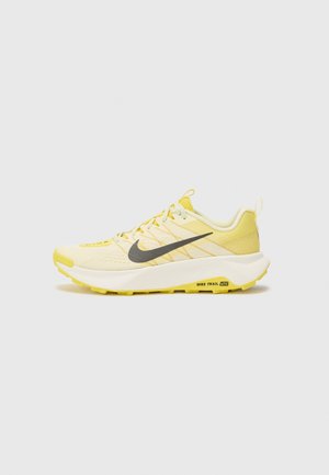 Baskets de sport jaunes avec une tige en maille texturée, logo Swoosh gris, design à lacets et semelle robuste pour une meilleure traction.