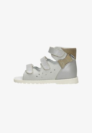 Scarpa in stile sandalo grigia con strap in velcro, materiale in suede e pelle, design perforato sui lati e suola in gomma bianca texturizzata.
