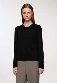 Czarny dzianinowy sweter polo z klasycznym kołnierzykiem, trzema brązowymi guzikami i długimi rękawami. Miękka struktura z dopasowanym krojem.