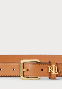 Karamelīgas krāsas ādas josta ar zelta sprādzi un piederumiem. Iezīmē piecas caurumiņu regulēšanai un "RL" logotipa detaļa uz jostas siksnas.