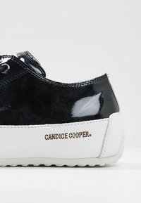 Musta patenttinopeus ja teksturoitu mokkanahkakengät valkoisella kumipohjalla. Sivussa "CANDICE COOPER." -brändäys. Mukana pyöreät nauhat.