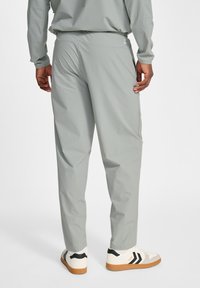 Grå letvægtsbukser med tekstureret finish, elastisk talje og sidelommer. Sæt sammen med hvide sneakers med sorte detaljer.