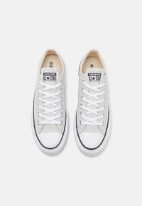 Graue Leinensneaker mit weißen Gummisohlen und Zehenkappen. Verfügt über weiße Schnürsenkel und ein schwarzes Logo-Patch mit "Converse ALL STAR."