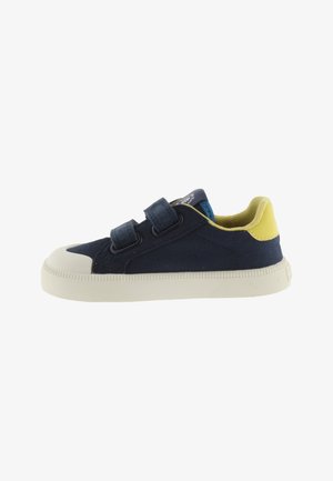 Donkerblauwe kindersneaker met witte rubberen zool, twee klittenbandsluitingen, gele hieltab en gele binnenvoering.
