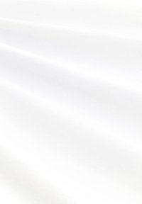 Tela blanca, suave, con pliegues sutiles y una textura blanda, que refleja la luz, indicando un material ligero.