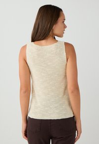 Gebreide mouwloze top in lichtbeige met een textuurfinish, voorzien van een ronde halslijn en een aansluitende vorm, afgewerkt op de taille.