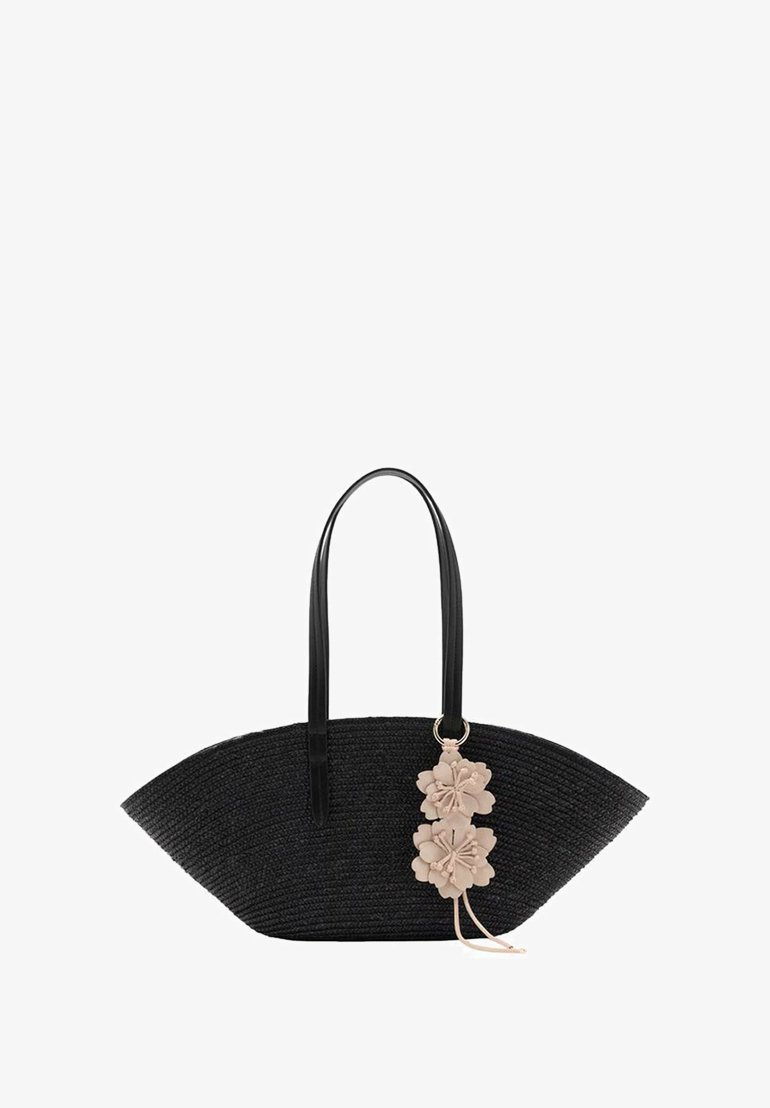 Borsa tote nera intrecciata con una forma angolare unica, dotata di manici in pelle nera e un dettaglio charm floreale rosa chiaro.