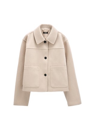 Beżowa krótka kurtka z szerokim kołnierzem, trzema czarnymi guzikami z przodu, długimi rękawami i dwoma dużymi przednimi kieszeniami.