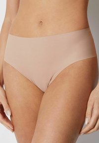 Ljusbeige sömlösa hipsterunderkläder med ett brett, slätt midjeband och en mjuk, matt finish. Tyget har en lätt stretch för komfort.