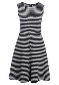 Robe sans manches en maille noire et blanche avec des rayures en zigzag horizontales et une taille cintrée, dotée d'une fermeture à glissière au dos.