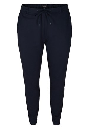 Tumedat sinised treeningpüksid, mis on valmistatud pehmest kangast, elastse vöökoha ja tõmbluku nööriga, kitsenevate jalgadega ning ilma nähtavate mustrite või aktsentideta.