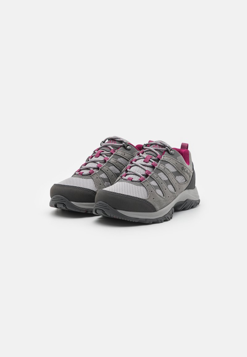 Des chaussures de randonnée grises présentent une tige en maille texturée avec des accents roses, un embout renforcé et une semelle en caoutchouc robuste pour une meilleure adhérence.